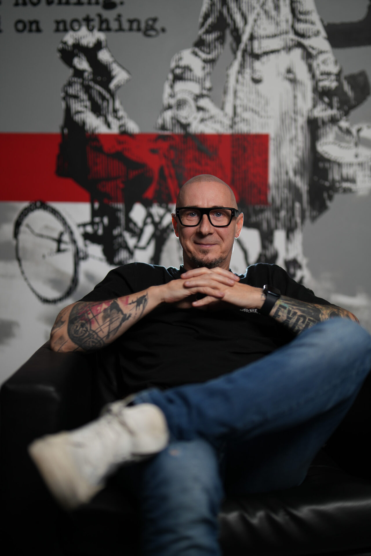 Headshot of tattoo artist Csaba, specializing in black and grey realism and trash polka tattoo, photographed in a studio setting